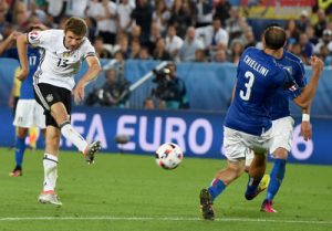 epa05404491 Thomas Mueller of Germany (L) shoots on goal during the UEFA EURO 2016 quarter final match between Germany and Italy at Stade de Bordeaux in Bordeaux, France, 02 July 2016. (RESTRICTIONS APPLY: For editorial news reporting purposes only. Not used for commercial or marketing purposes without prior written approval of UEFA. Images must appear as still images and must not emulate match action video footage. Photographs published in online publications (whether via the Internet or otherwise) shall have an interval of at least 20 seconds between the posting.)  EPA/VASSIL DONEV   EDITORIAL USE ONLY